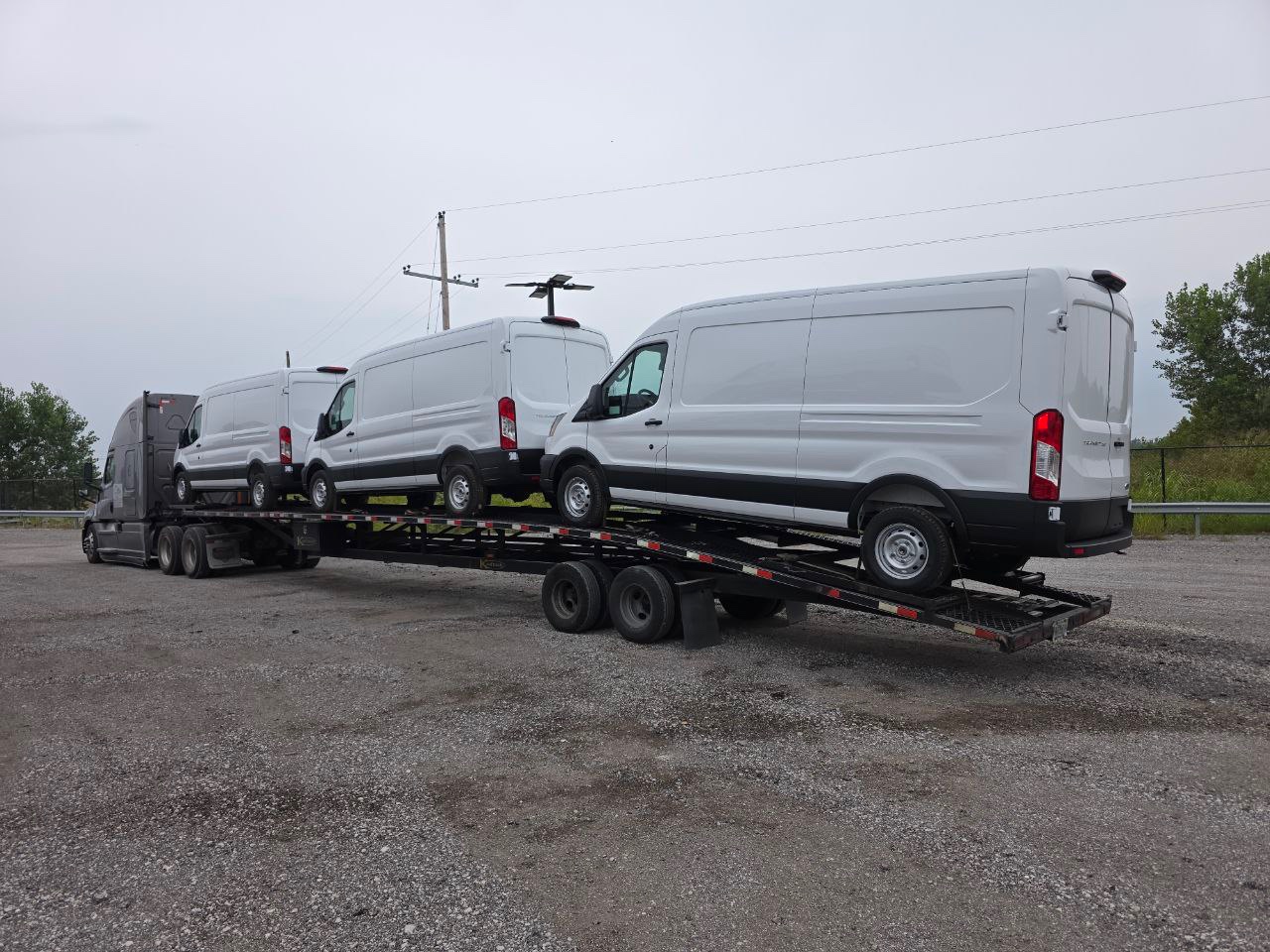 Fleet of Ford Transit vans on flatbed transport